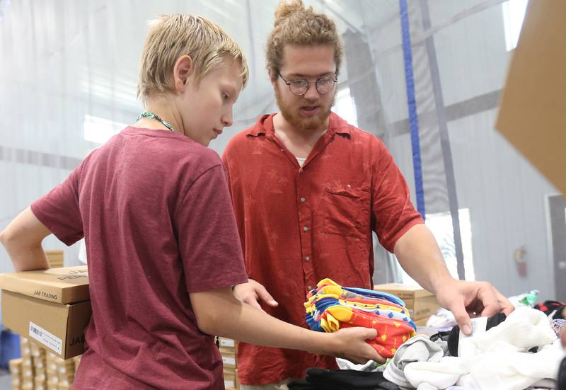 Blaze Norman of Princeton, picks out a pair of socks with Second Story Teen Center volunteer Dominic Schallaci during the Shoes and Socks Giveaway on Saturday, Aug. 2, 2025 at the Second Story Teen Center in Princeton.