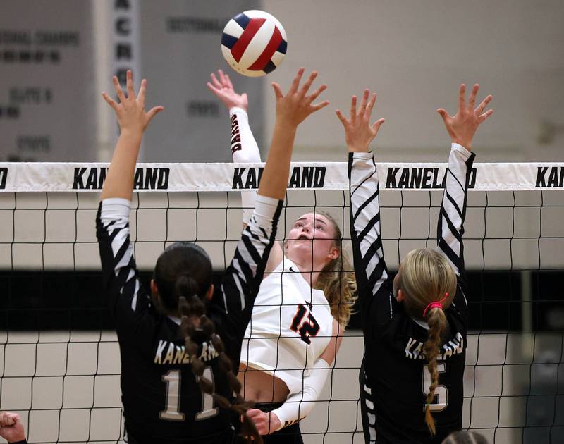 DeKalb's Isabelle Smith tries to spike the ball by Kaneland's Natalie Remsen (left) and Abigail Carter Thursday, Sept. 4, 2025, during their match at Kaneland High School in Maple Park.