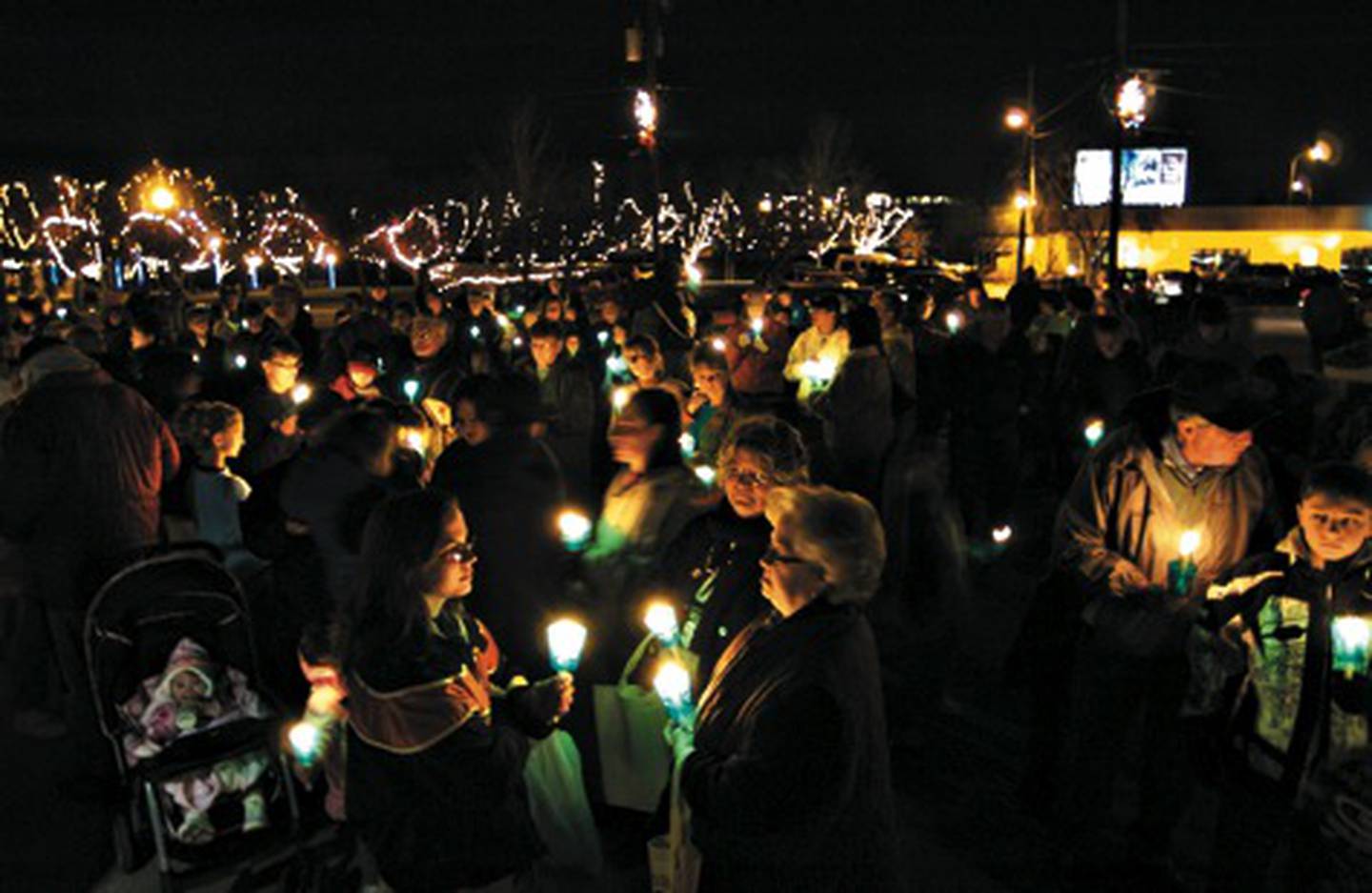 Candles and holiday lights cut through the darkness on a pleasant evening in Rock Falls as revelers wait for the lighting of the Love Light tree for the Hometown Holidays celebration.