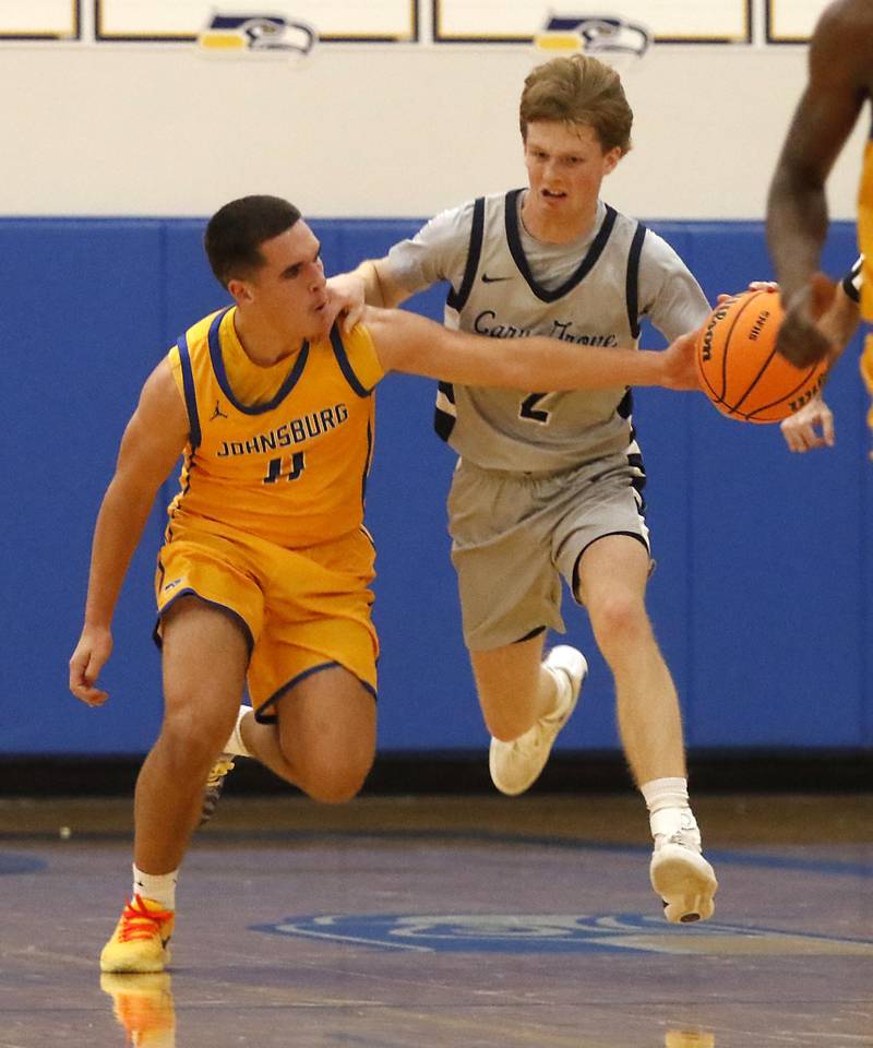 Johnsburg's Ryan Franze fouls Cary-Grove's AJ Berndt as he tries to steal the ball during a Johnsburg Thanksgiving Tournament boys basketball game on Monday, Nov. 24, 2025, at Johnsburg High School.