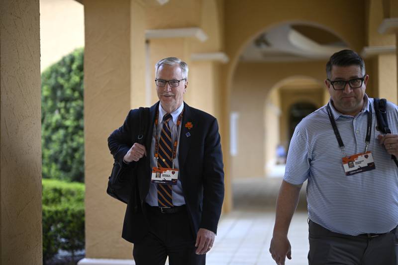 Chicago Bears Chairman George H. McCaskey, left, walks to an interview at the NFL football owners meetings, Tuesday, March 26, 2024, in Orlando, Fla. (AP Photo/Phelan M. Ebenhack)