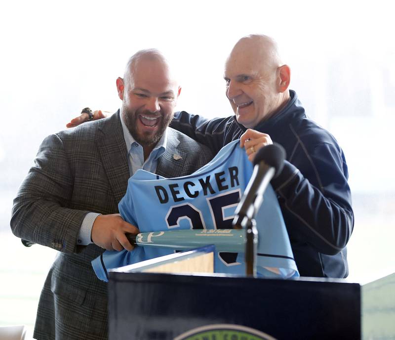 Former Kane County Cougars owner Bob Froehlich, right, holds a jersey with President of REV Entertainment Sean Decker before Rev Entertainment announced they are the new owners of the Kane County Cougars during a press conference Wednesday, April 2, 2025 at Northwestern Medicine Field in Geneva Ill.