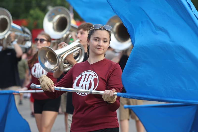 A member of the color guard spins a flag as the Lockport Marching Band performs along the Old Canal Days Parade on Friday June 7, 2024 in Lockport.