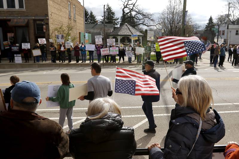 Diane Boothbay and Pam Pedersen wave upside down American flags as protesters line U.S. Route 12 in Richmond to protest their discontent with President Donald Trump and his administration's policies on Saturday, April 19, 2025. Over 100, people took part in the Richmond protest. A second rally was held in Harvard later in the day.