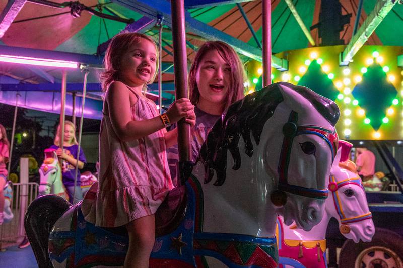 (from left) Luna Dixon, 3, rides carousel with mother Kendra Jurkas at the annual Tri-County Fair on Thursday, Aug 28, 2025 at the Tri-County Fairgrounds in Mendota.