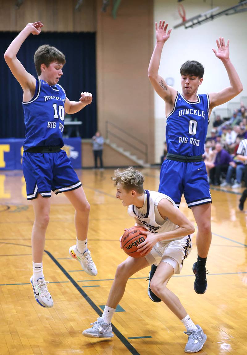 Serena's Carson Baker gets Hinckley-Big Rock's Max Hintzsche (left) and Landon Roop up in the air with a pump fake Friday, Feb. 3, 2023, during the championship game of the Little 10 Conference Basketball Tournament at Somonauk High School.