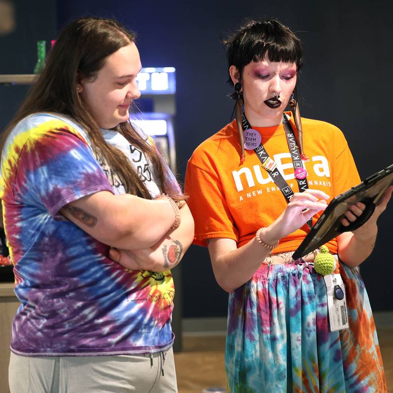 Ezra Miner, (right) a budtender at nuEra cannabis dispensary, talks to customer Emma Ingram, from DeKalb, Thursday, May 23, 2024, about some of the products offered at the new business in DeKalb. Thursday was opening day for the dispensary which is located at 818 West Lincoln Highway, in the Junction Shopping Center.