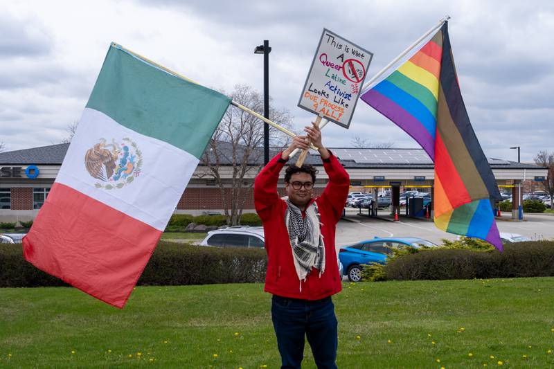 Rolando Serna holds up a LGTBQ+ and Mexico flags during the Hands Off protest along Randall Road in South Elgin, IL to protest their issues with President Donald J. Trump and his administration and Elon Musk involvement in US government affairs on Saturday April 19, 2025.  Hundreds of protesters participated in the latest Hands Off protest occurring in the Chicagoland area and the rest of the country.