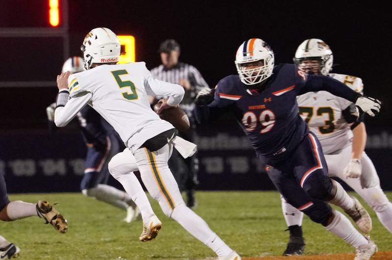Oswego’s Joshua Flores (99) forces Waubonsie Valley's Josh (5) out of the pocket during a Class 8A first-round playoff game at Oswego High School on Friday, Nov. 1, 2024.