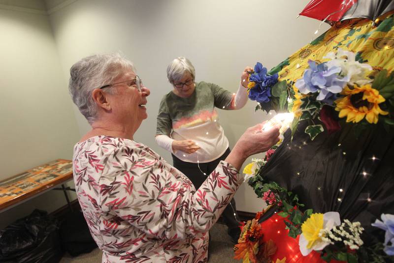 Gail Kirkham, of Lindenhurst works with Paula Engelman, of Grayslake putting lights on the Grayslake Greenery Garden Club tree which will be on display in the Giving Trees exhibit at the Grayslake Heritage Center & Museum.