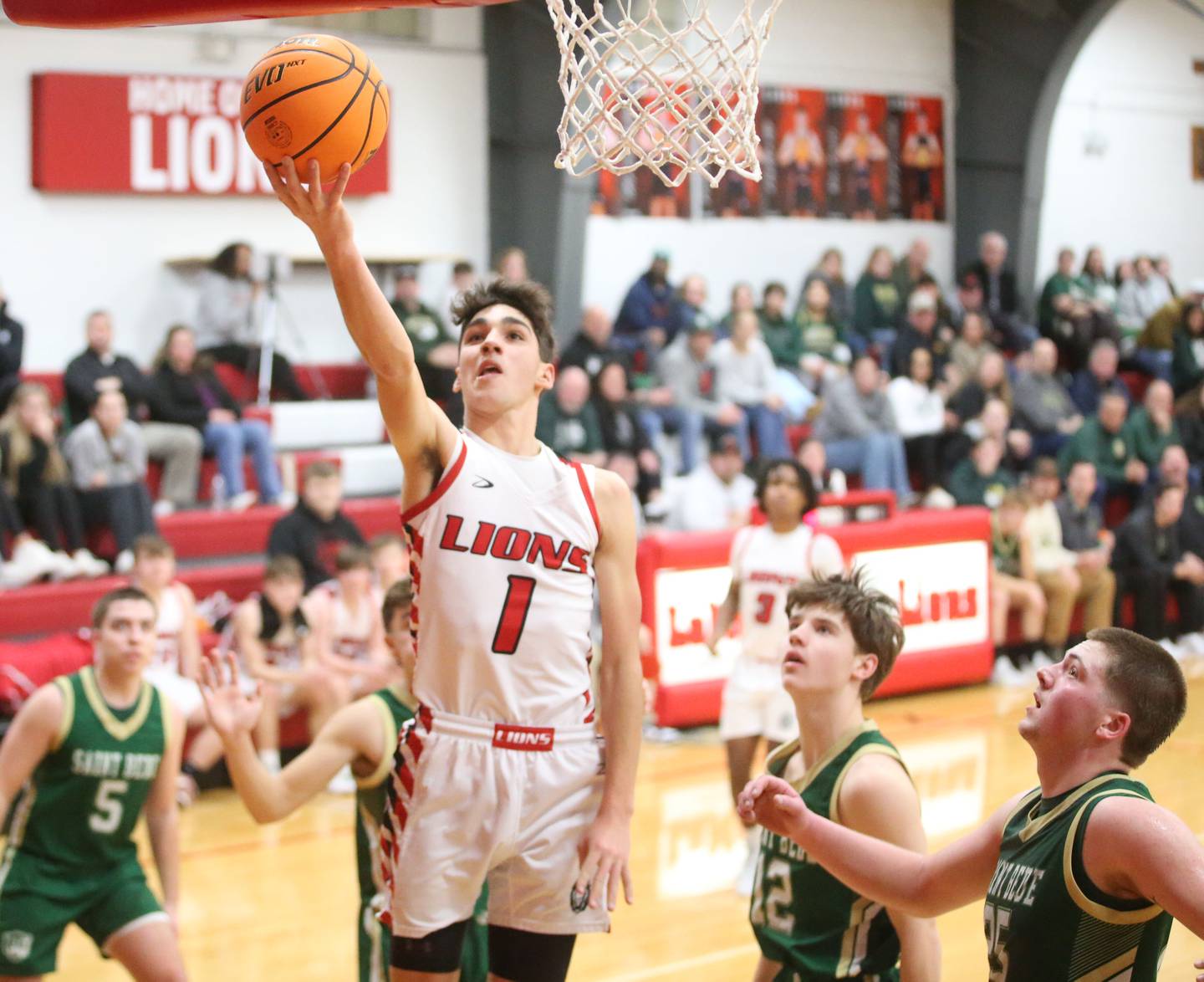LaMoille's Tyler Billhorn runs in the lane to score on a layup over St. Bede's  Carson Riva and Jake Miglorini on Tuesday, Feb. 11, 2025 at LaMoille High School.
