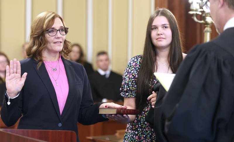 Jill K. Konen is sworn in as an associate judge of the 23rd Judicial Circuit Court by Chief Judge Bradley Waller of the 23rd Judicial Circuit as her daughter Amelia Konen holds the bible Friday, Sept. 23, 2022, at the DeKalb County Courthouse in Sycamore.