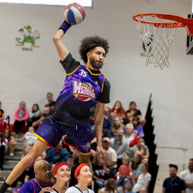 Tyler “Sky-Rise” Cronk (35) of the Harlem Wizards dunks over 3 people on Wednesday, April 16, 2025 at Woodland High School in Streator.