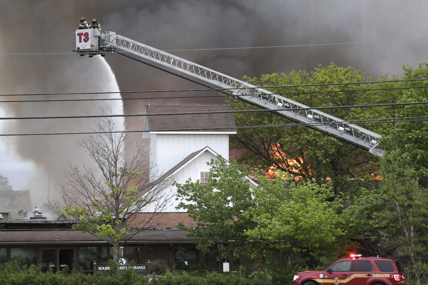 Ladder trucks are employed as firefighters battle a structure fire at the former Pheasant Run Resort on Saturday in St. Charles.