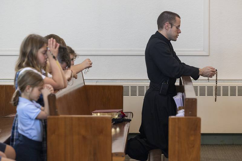 Father Timothy Draper leads school children in praying the rosary Wednesday, April 23, 2025, at St. Anne’s Church in Dixon. Students, staff and parishioners were invited in to pray for the recently deceased Pope Francis.