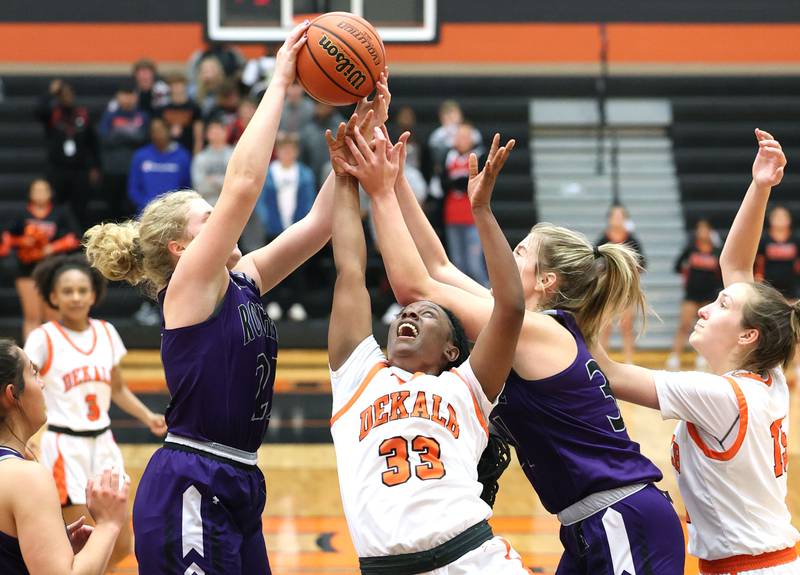 DeKalb's Cayla Evans goes after a rebound between two Rochelle players for a layup during their game Monday, Nov. 28, 2022, at DeKalb High School.