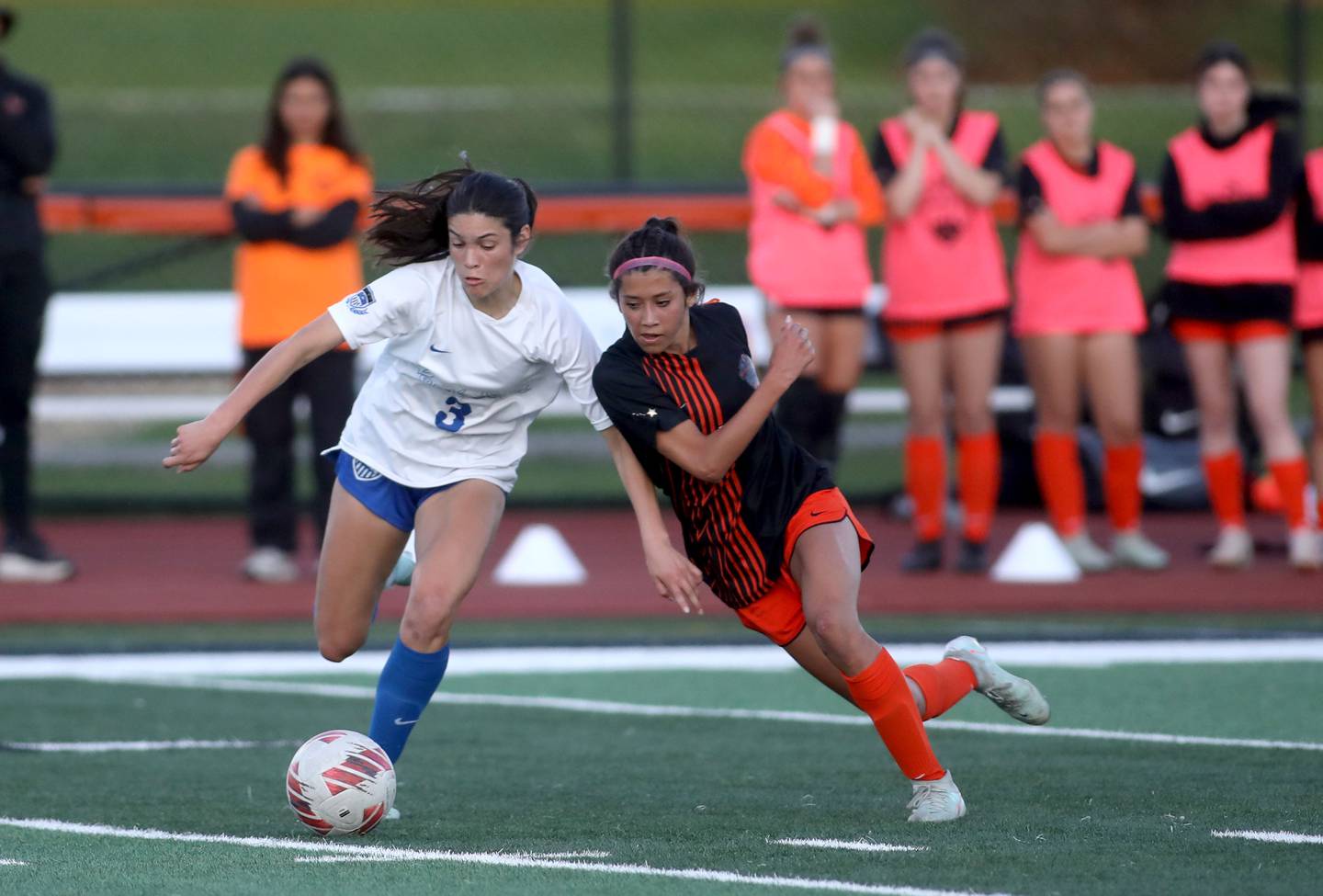 St. Charles North’s Aubri Magana (left) and St. Charles East's Mya Leon go after the ball during a Tri-Cities Soccer Night game on Tuesday, April 29, 2025 in St. Charles.