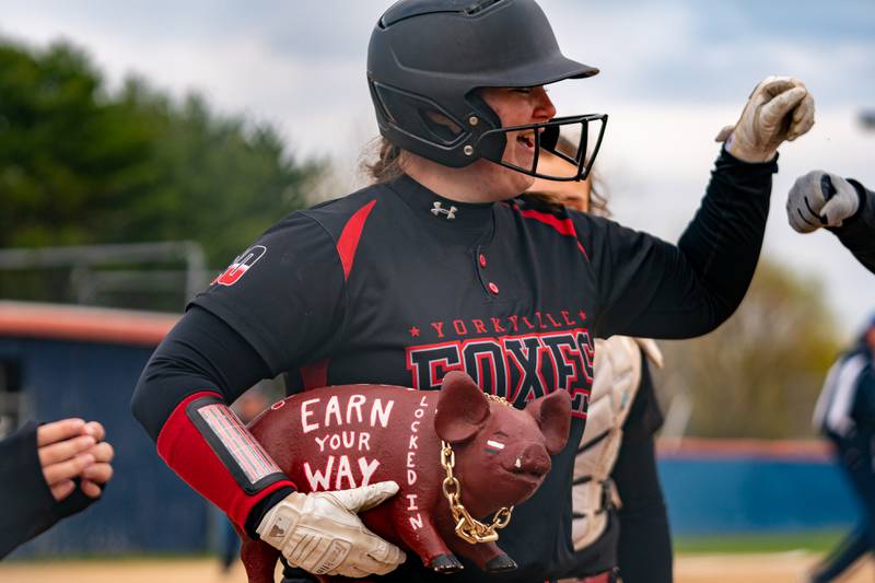 Yorkville's Jensen Krantz (20) carries the team pig after hitting a homer against Oswego during a softball game at Oswego High School on Tuesday, April 25, 2023.