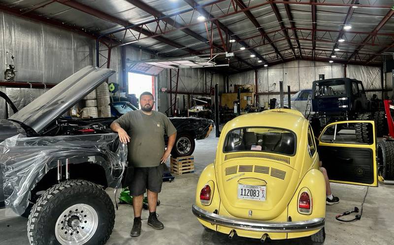 Steel Town Speed owner Tyler Felder stands among his custom classic car builds in Rock Falls, Illinois.