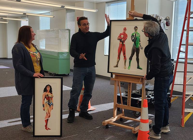 Robin Hill, exhibition and design manager (left), and Steve Furnett (right), exhibitions and collection manager at the Dunn Museum, discuss a new exhibit with Alex Ross’ manager, Sal Abbinanti.