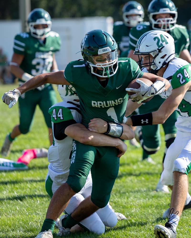 Jose De Le Torre (1) of St. Bede runs ball as Zach Bumpous (44) of Dwight holds onto waist in attempt to bring him down on Saturday, Oct. 4, 2025 at Captain Thomas J. Heitmann field in Peru.