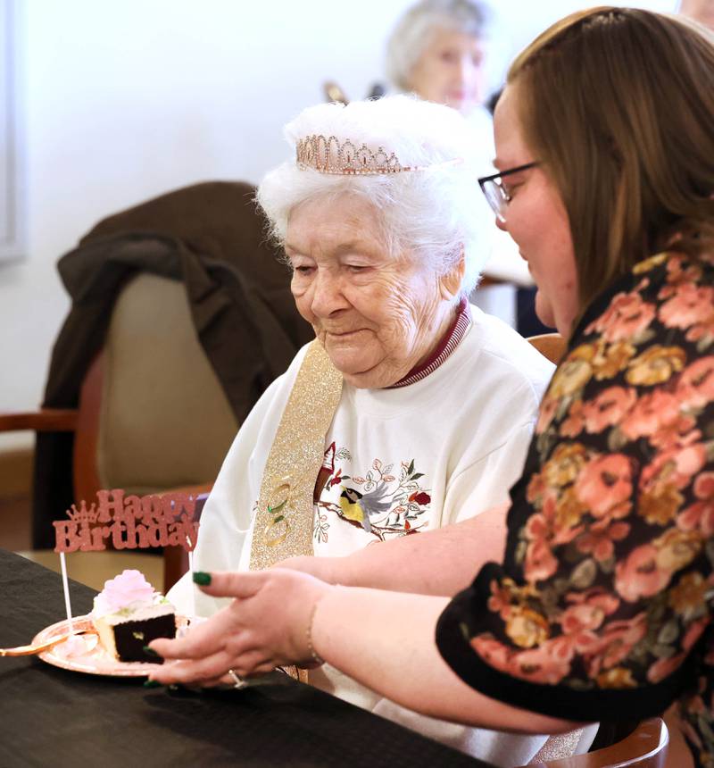 Heritage Woods of DeKalb resident Phyllis Fawcett, gets a piece of cake from Lindsey Oas, Heritage Woods marketing director, during her surprise 100th birthday party Thursday, March 21, 2024, at the complex.
