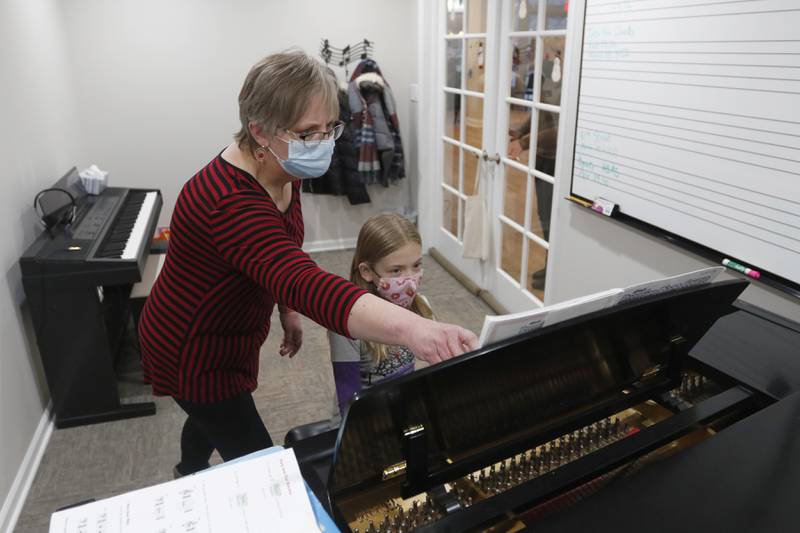 Piano teacher Sherry Taliaferro teaches Claire Koll, 8, of Crystal Lake, during a lesson Tuesday, Feb. 22, 2022, at Encore Music Academy, 87 N. Williams St., in Crystal Lake. The academy moved into its new location over Thanksgiving week last year. The larger location allows for the expansion of its private student instruction and also has a large space suitable for performing.