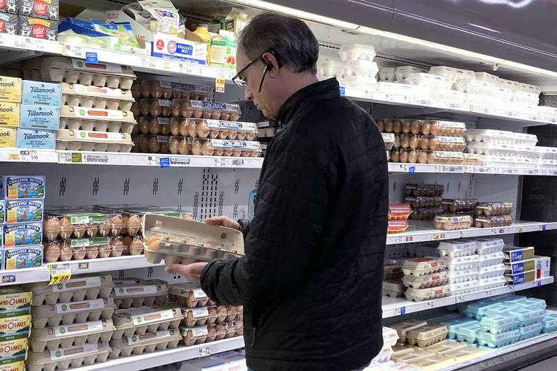 FILE - A shopper checks eggs before he purchases at a grocery store in Glenview, Ill., Tuesday, Jan. 10, 2023.  (AP Photo/Nam Y. Huh, File)