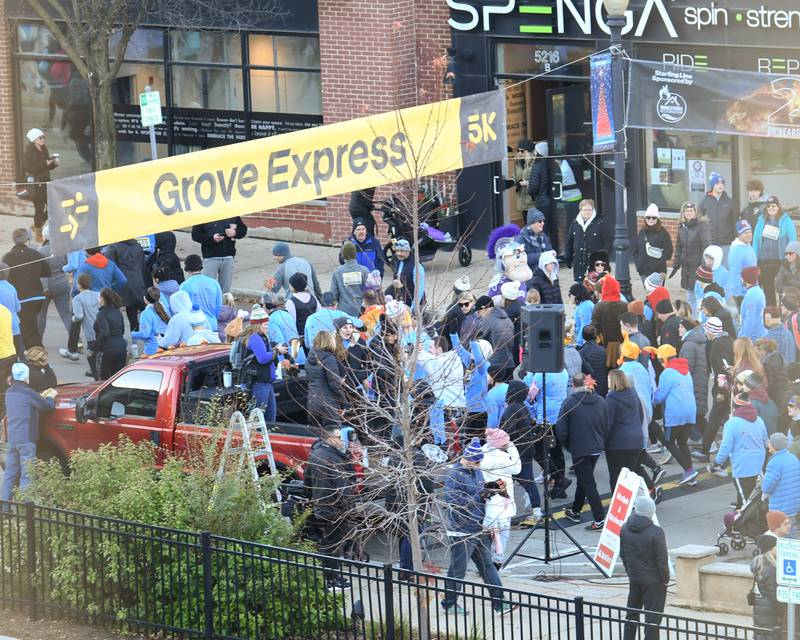 Participants in the Grove Express take off from the start line on Main Street in Downers Grove on Thursday Nov. 23, 2023.
