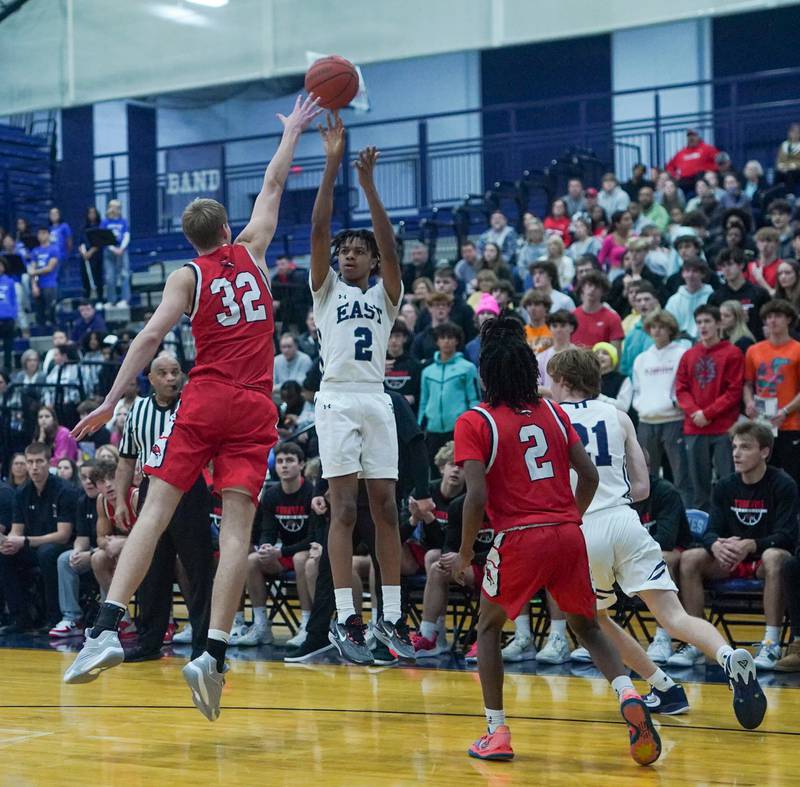 Oswego East's Mason Lockett IV (2) shoots a three pointer over Yorkville's Jason Jakstys (32) during a basketball game at Oswego East High School on Friday, Dec 8, 2023.