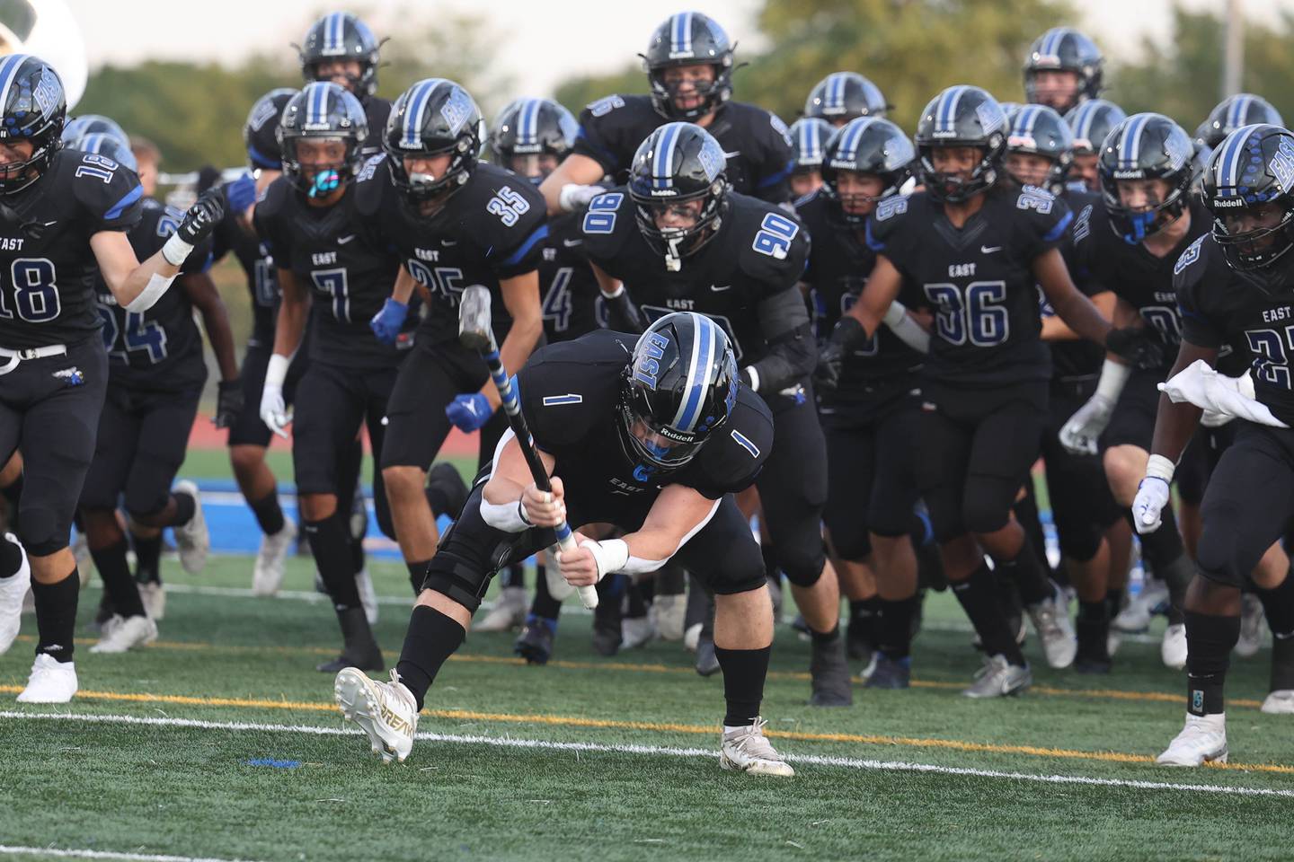 Lincoln-Way East’s Jake Scianna does the traditional sledge hammer slam as the team enters the field before the game against Batavia. Friday, Sept. 2, 2022, in Frankfort.
