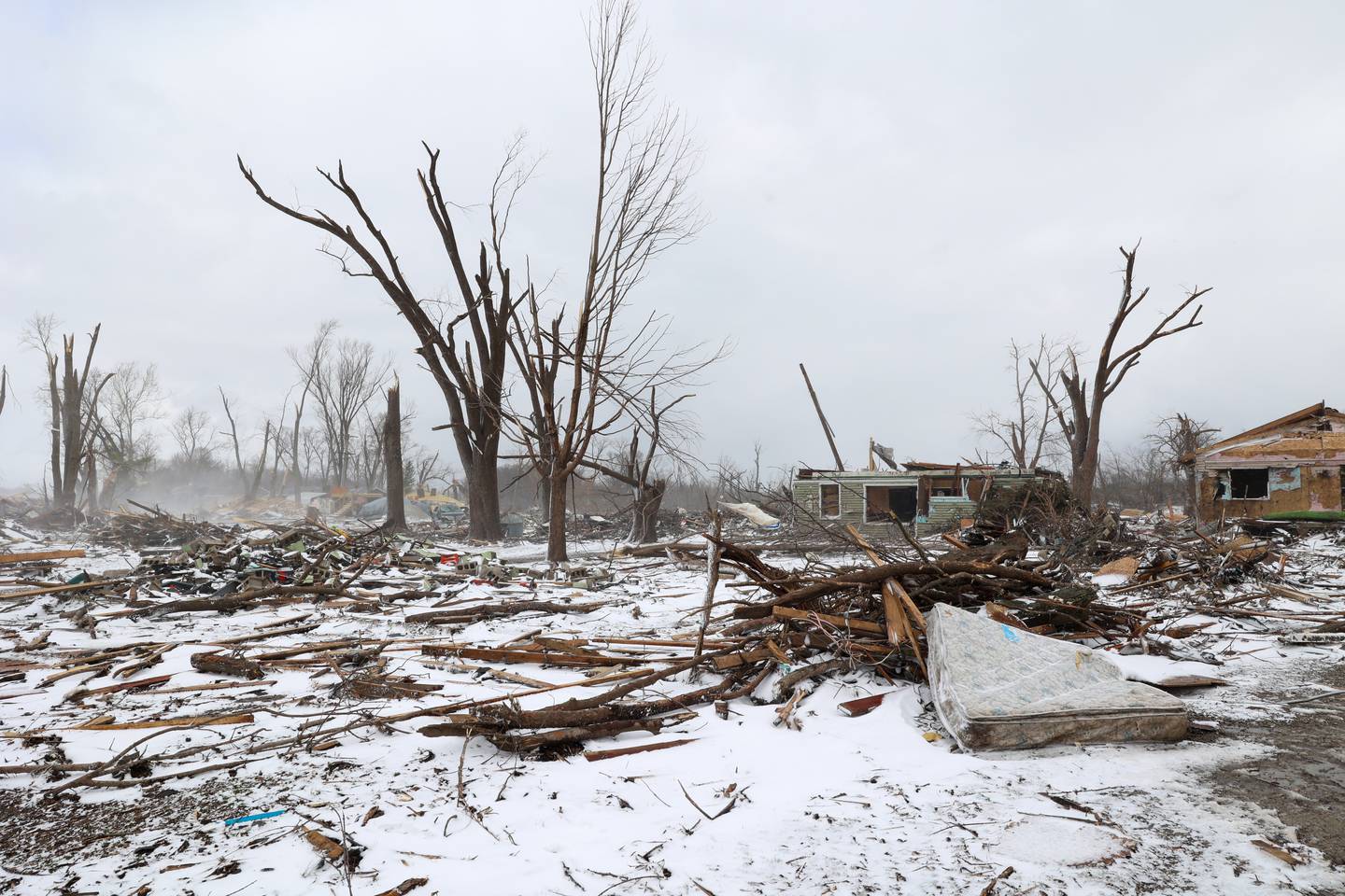 Snow falls on the destroyed homes along South Sandbar Road in Aroma Township on March 16, 2026, following the March 10 EF-3 intensity tornado in Kankakee County.