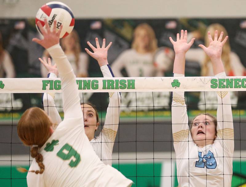 Seneca's Brooklyn Sheedy sends a spike past Marquette's Kaitlyn Davis and teammate Gwen Jimenez on Thursday, Sept. 19, 2024 at Seneca High School.
