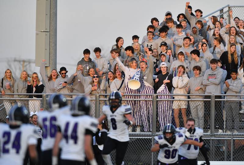 The Downers Grove North student section erupts along with their victorious football team as the final buzzer sounds ending an IHSA Class 7A quarterfinal game against Lincoln-Way West on Nov. 11, 2023 at Lincoln-Way West High School in New Lenox.