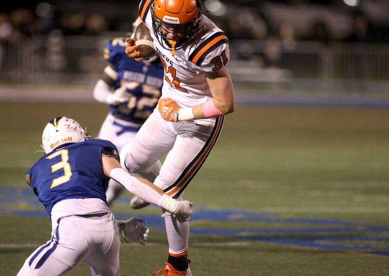 Wheaton Warrenville South’s Colin Moore carries the ball over Wheaton North’s Nick Morici (3) during a game at Wheaton North on Friday, Oct. 7, 2022.
