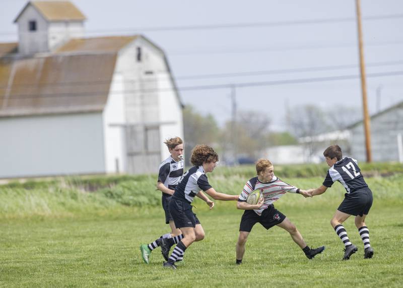Jack O'Brien of the Stallions Ruby Club tries the break away from the grip of 2 West Suburban Barbarians players during the rugby game at Veterans Park on April 28, 2024.