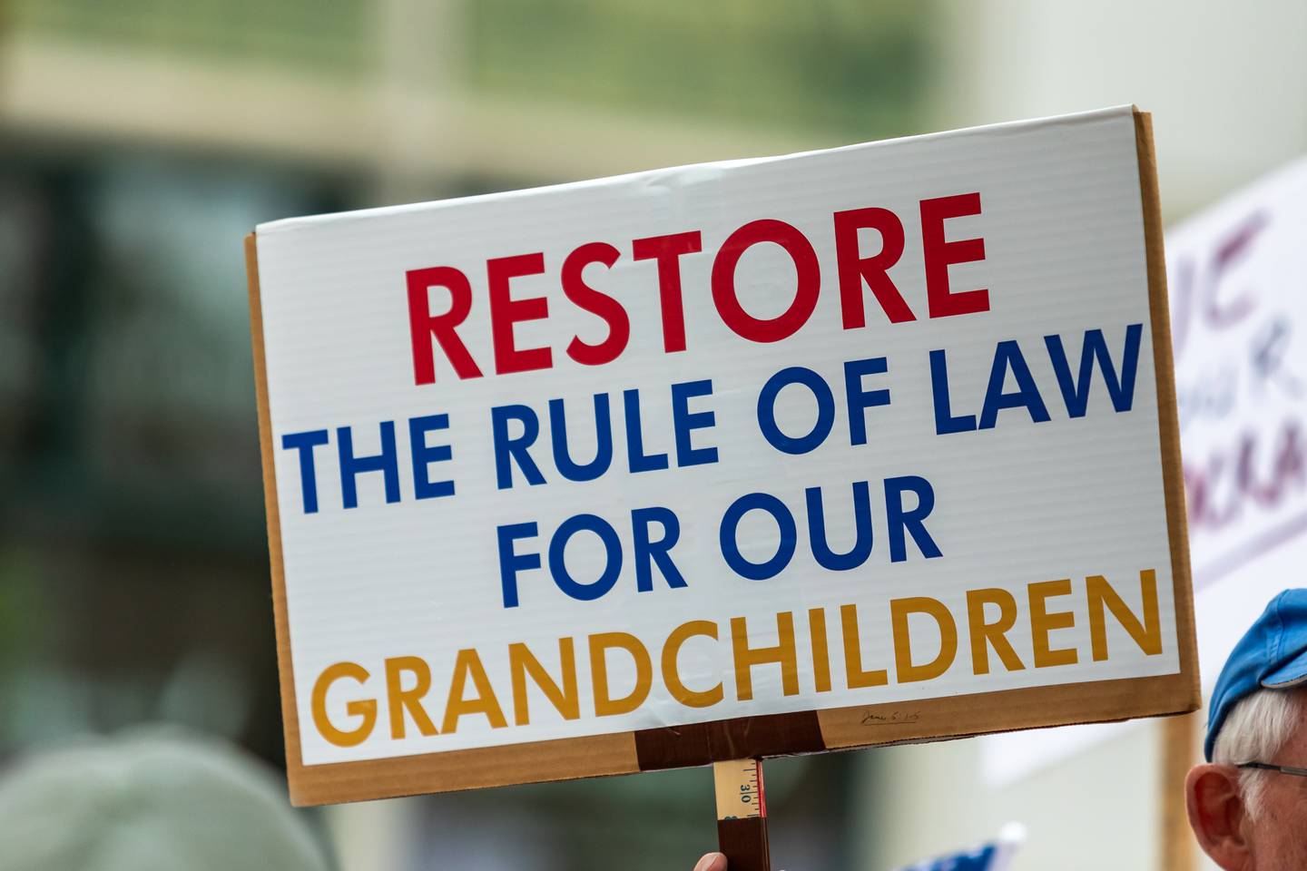 An attendee holds up a sign at the Good Trouble Lives On event in Downtown Joliet on July 17, 2025.