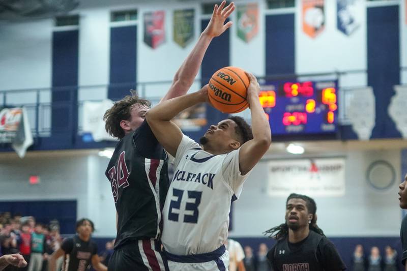 Oswego East's Torrin Ross (23) shoots the ball in the post against Plainfield North's Quintin Wiencek (34) during a basketball game at Oswego East High School on Friday, Dec. 6, 2024.