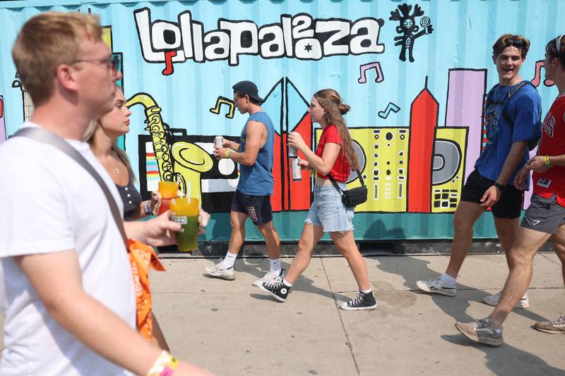 Festival goers walk past a Lollapalooza mural at Lollapalooza on Saturday, Aug. 3, 2024 in Chicago.