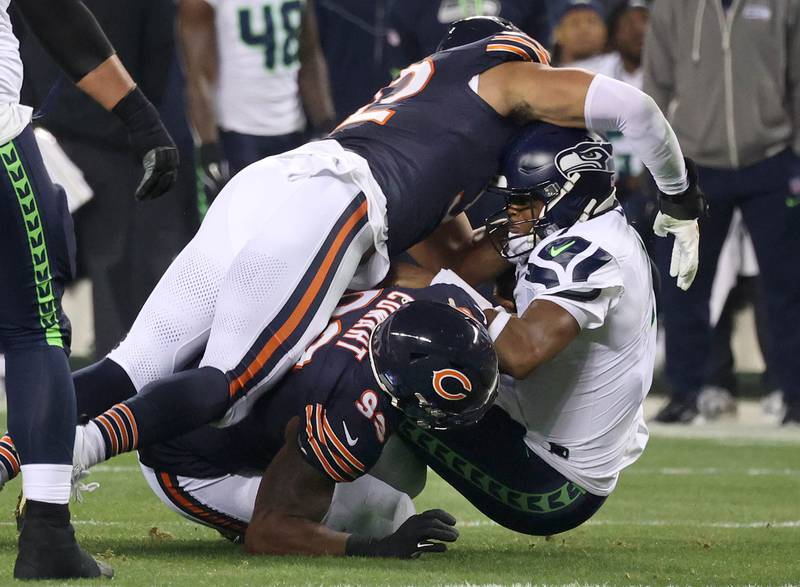 Chicago Bears defensive tackle Byron Cowart and Chicago Bears defensive end Daniel Hardy sack Seattle Seahawks quarterback Geno Smith during their game Sunday, Dec. 26, 2024, at Soldier Field in Chicago.