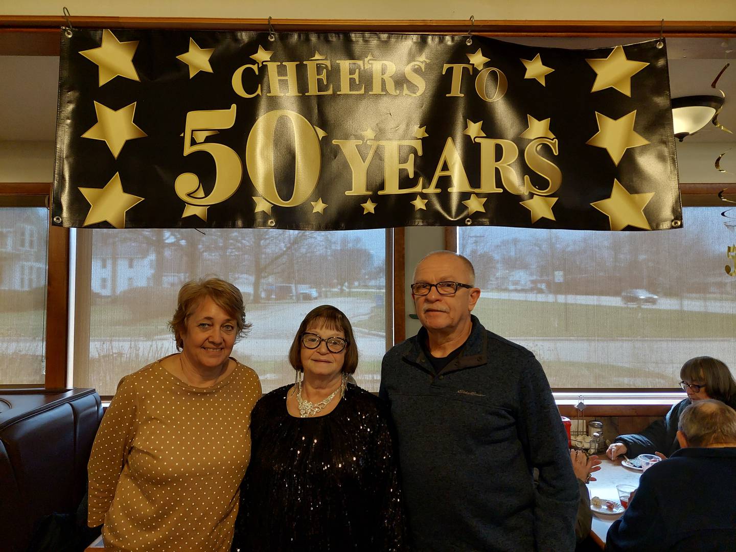 New Chalet owners Cheryl and Dave Park stand on each side of Sandy Batistini as she is celebrated for her 50 years of working as a waitress at the restaurant.