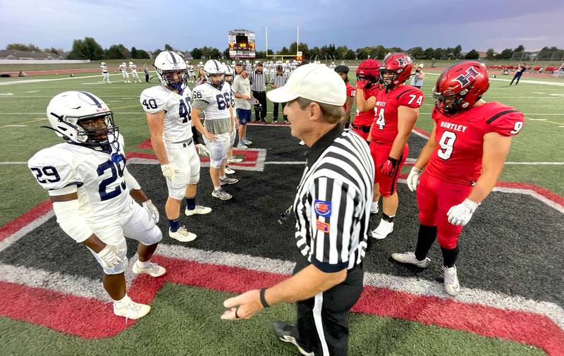 Elias Berthelsen, far left, and the Trojans of Cary-Grove line up for the pregame coin toss in varsity football at Huntley High School in Huntley on Friday, Sept. 19, 2025.
