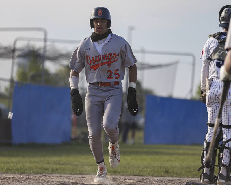 Oswego's Kam Jenkins (25) crosses the plate to score a run during baseball game between Oswego East at Oswego. Monday, May 19, 2025 in Oswego.