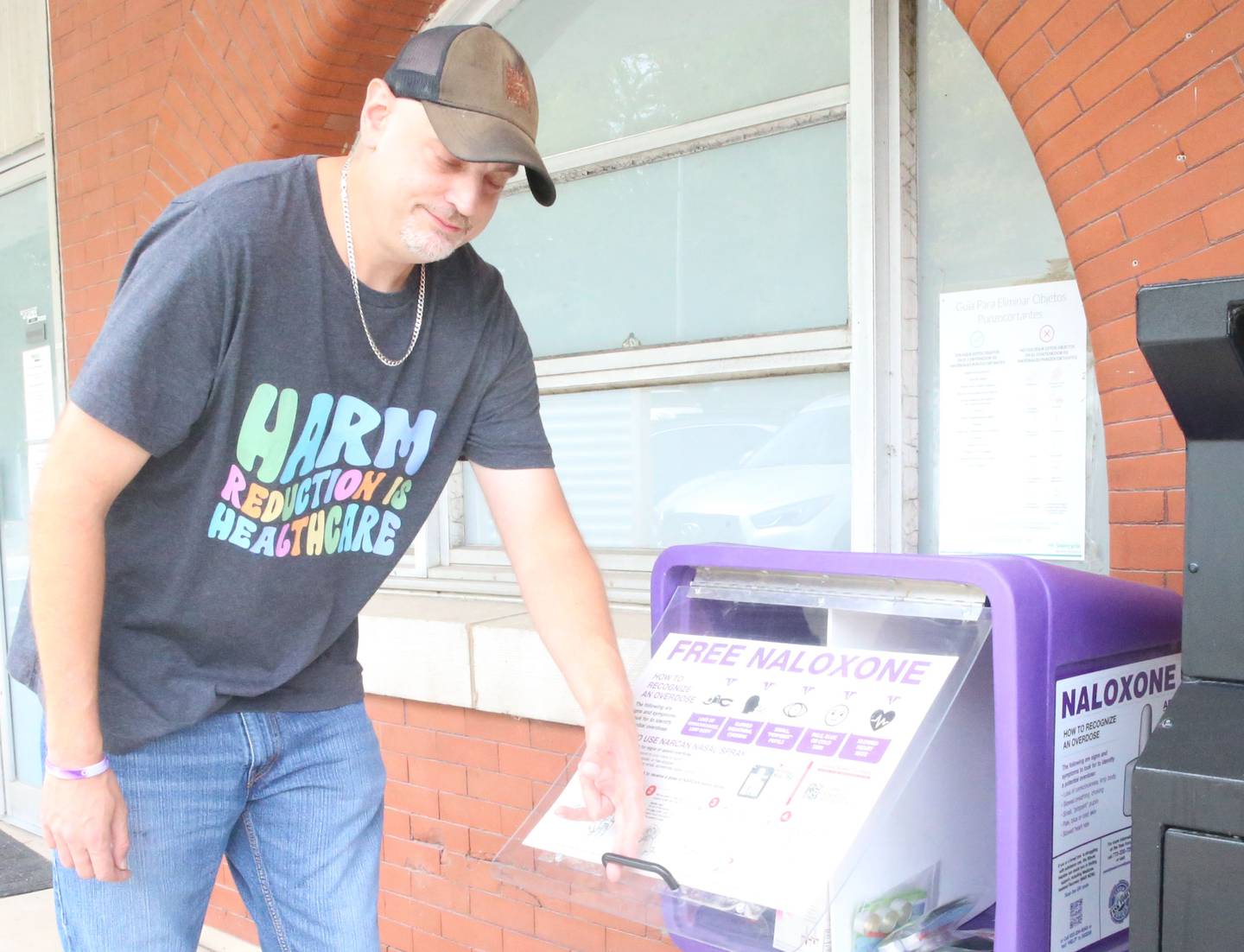 Matt Rowlee, director of outreach and drug technician at Perfectly Flawed, fills the free naloxone dispenser on Thursday, Oct. 16, 2025 at their office in La Salle.