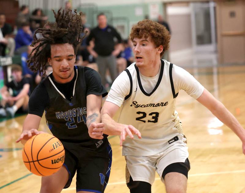Woodstock's Jeremy Stokes gets a shot up in front of Sycamore's Aidan Mesenbrink (left)  and Sycamore's Josiah Mitchell Friday, Feb. 27, 2026, during their IHSA Class 3A boys basketball regional championship game at Boylan Catholic High School in Rockford.
