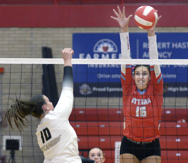 Ottawa’s Bella Knoll reaches to block a shot by Sycamore’s Sophia Lichthardt in the 1st set of Tuesday’s match at Ottawa.