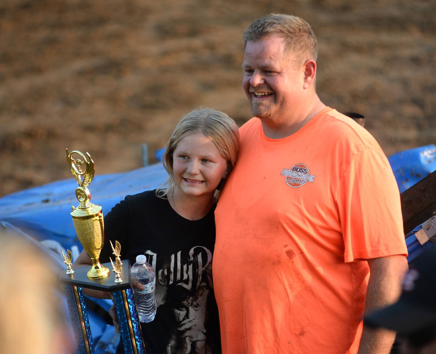 Aubree Boss, 12, and her dad, Brick, pose for a photo with their third-place trophy at the end of the Young Guns heat at the Ogle County Fair's demolition derby Saturday, Aug. 2, 2025.