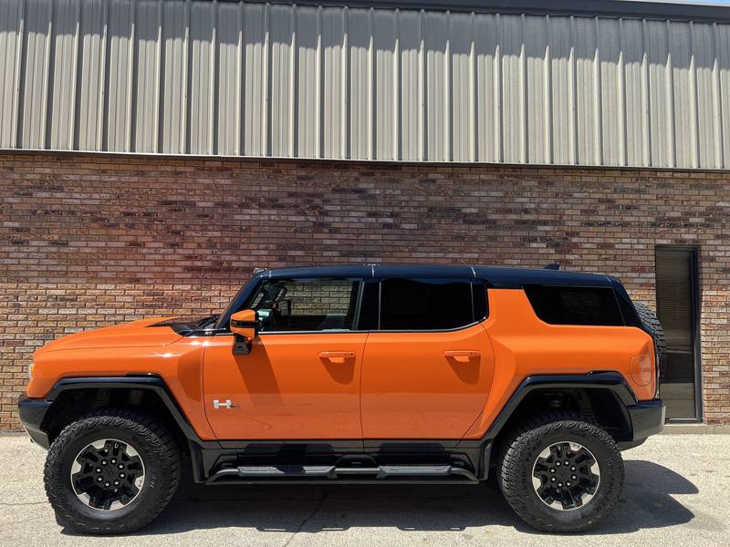 The 2024 Hummer EV in an imposing Afterburner Tincoat hue.