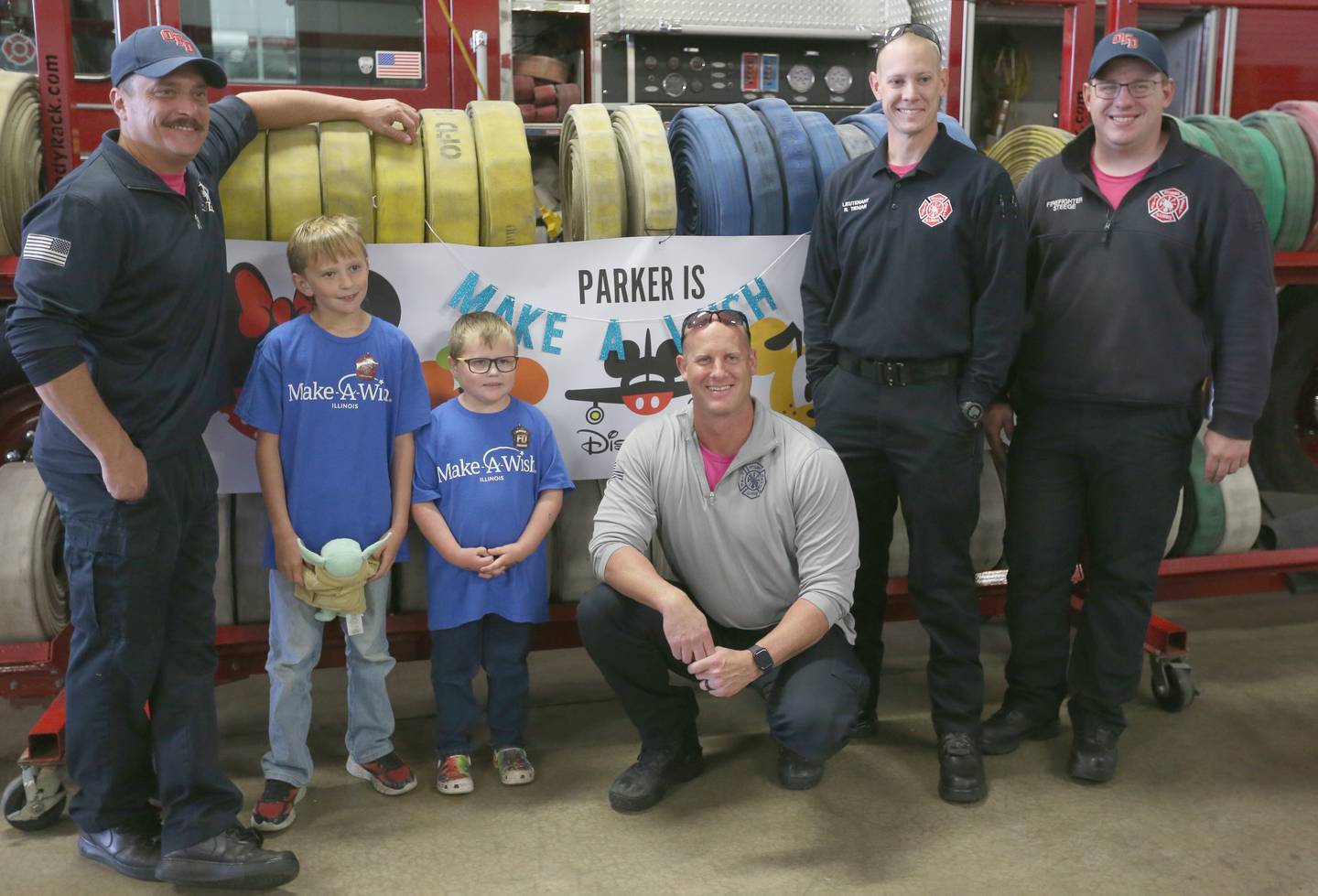 Parker Vangalder 6, of Seneca, and his brother Colton pose with Ottawa firefighters Nick Allegretti, lieutenant Kevin Theis, Ryan Teman, and Mike Steege Monday, Oct. 10, 2022. Vangelder and his family are going to Walt Disney World later this month courtesy of Make-A-Wish.