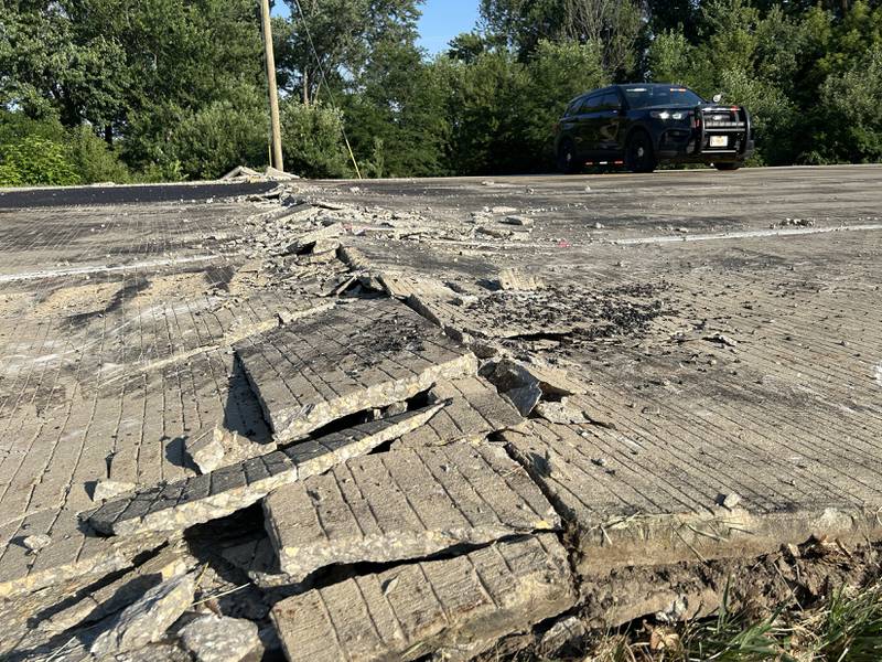 An Ogle County squad car stops motorists from traveling over buckled pavement on Illinois Route 2 Wednesday, July 2, 2025. It was the second time in 24 hours that pavement buckled between Oregon and Byron causing traffic to be detoured around a portion of the busy state highway.